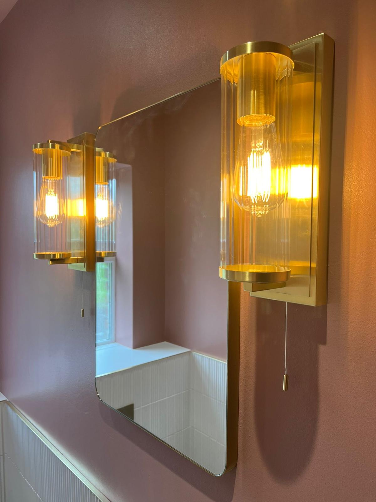 Ribbed glass and brushed brass wall light beside the cloakroom mirror