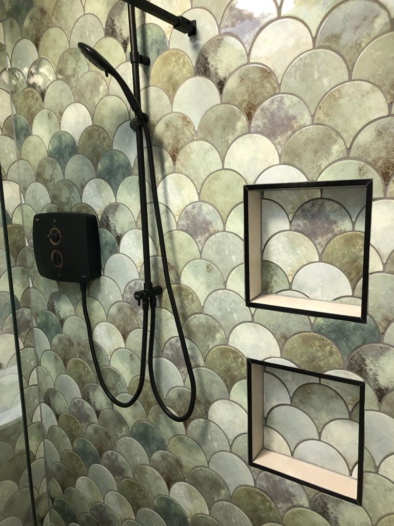 Walk-in shower with sage fish-scale tile, matt black shower and electric shower unit