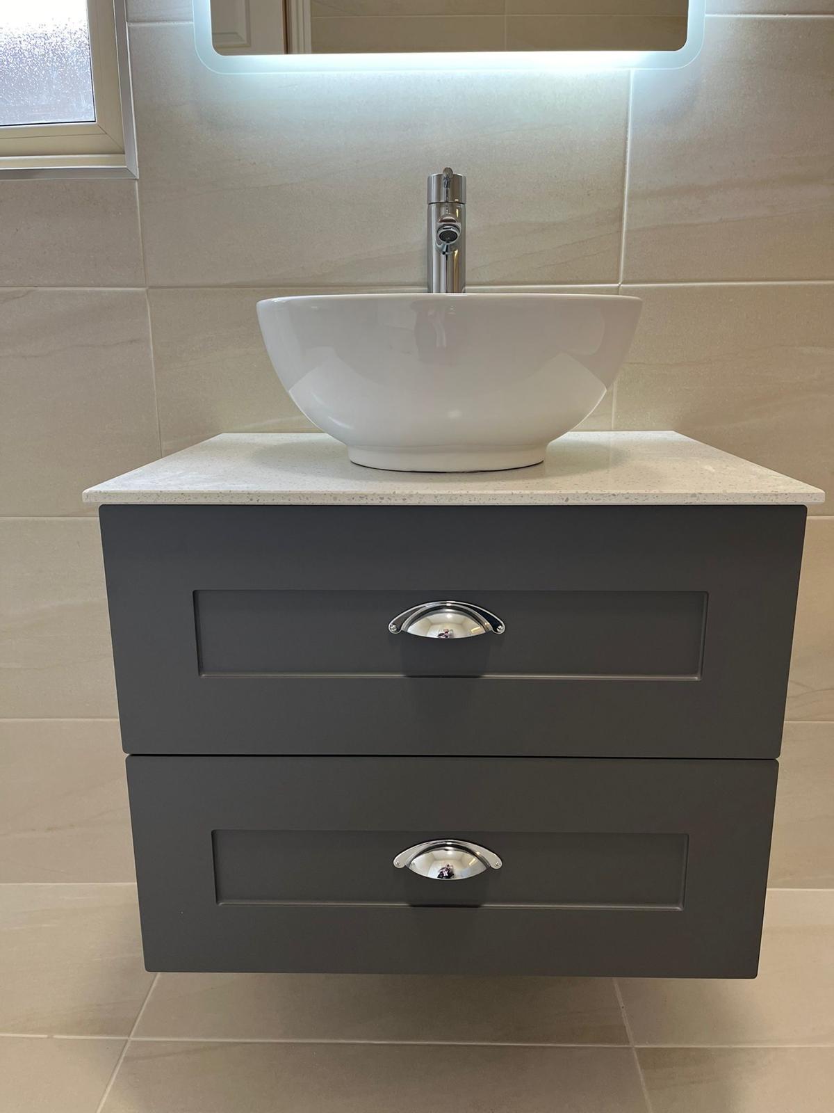 Counter-top bowl basin on a graphite shaker vanity with quartz top and backlit mirror