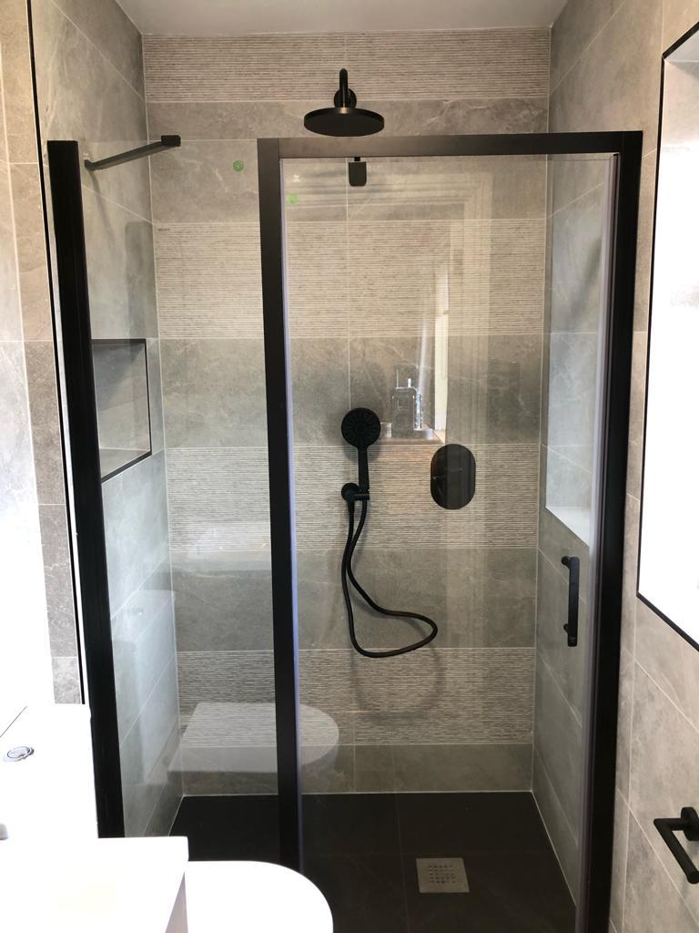 Black-framed shower enclosure with grey stone porcelain and ribbed feature tile