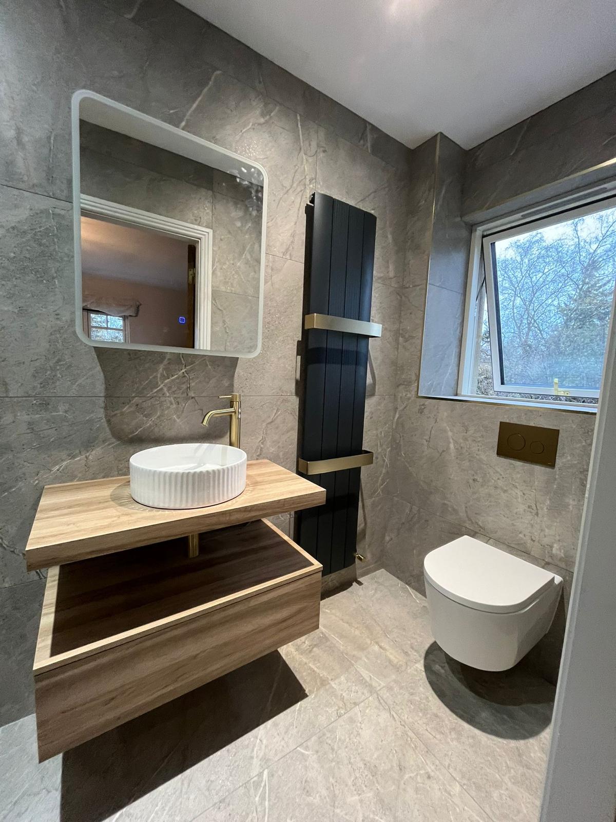 Wall-hung WC, black vertical radiator and floating oak vanity
