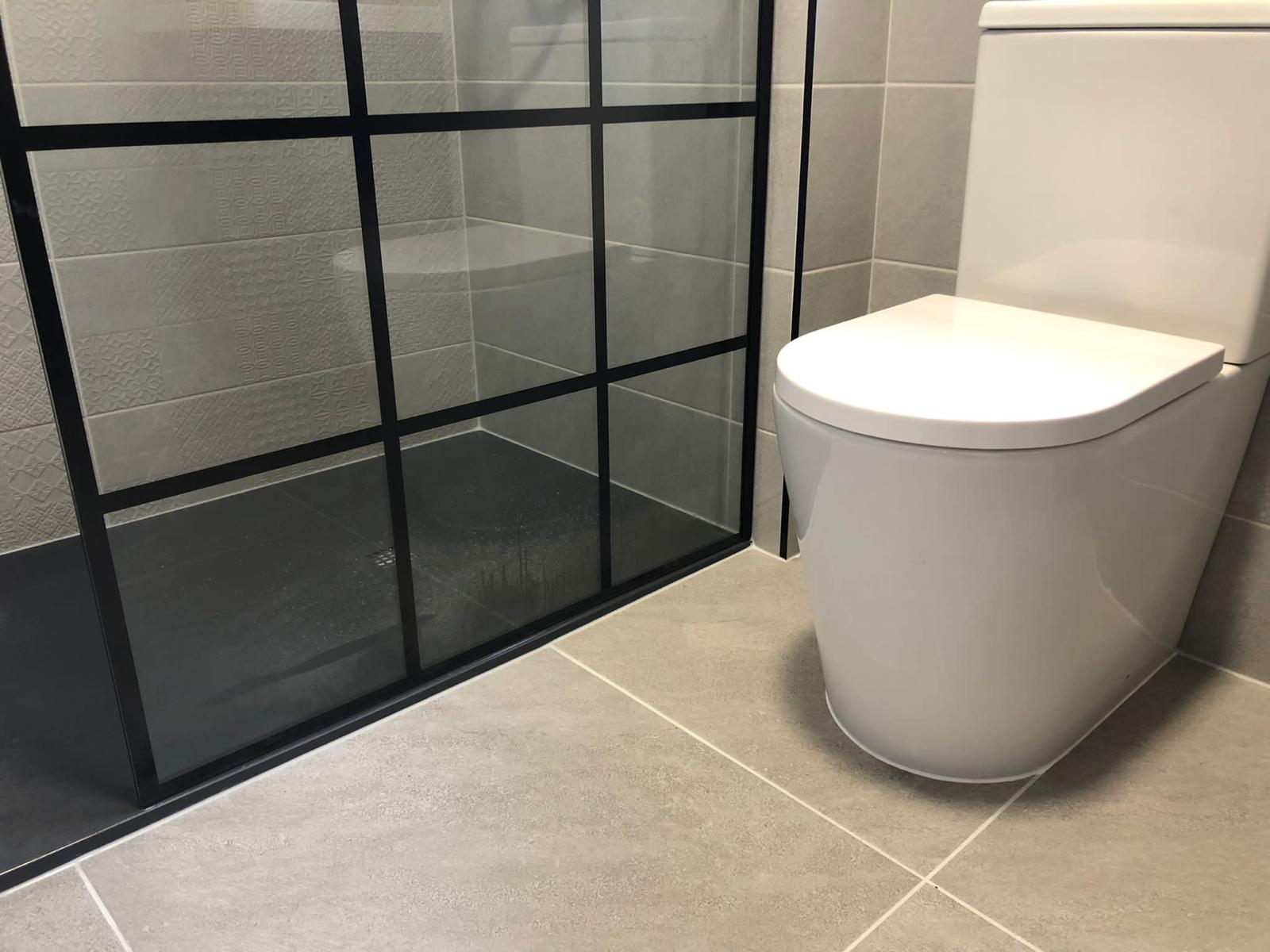 Embossed patterned feature tile behind the crittall screen with a rimless back-to-wall WC